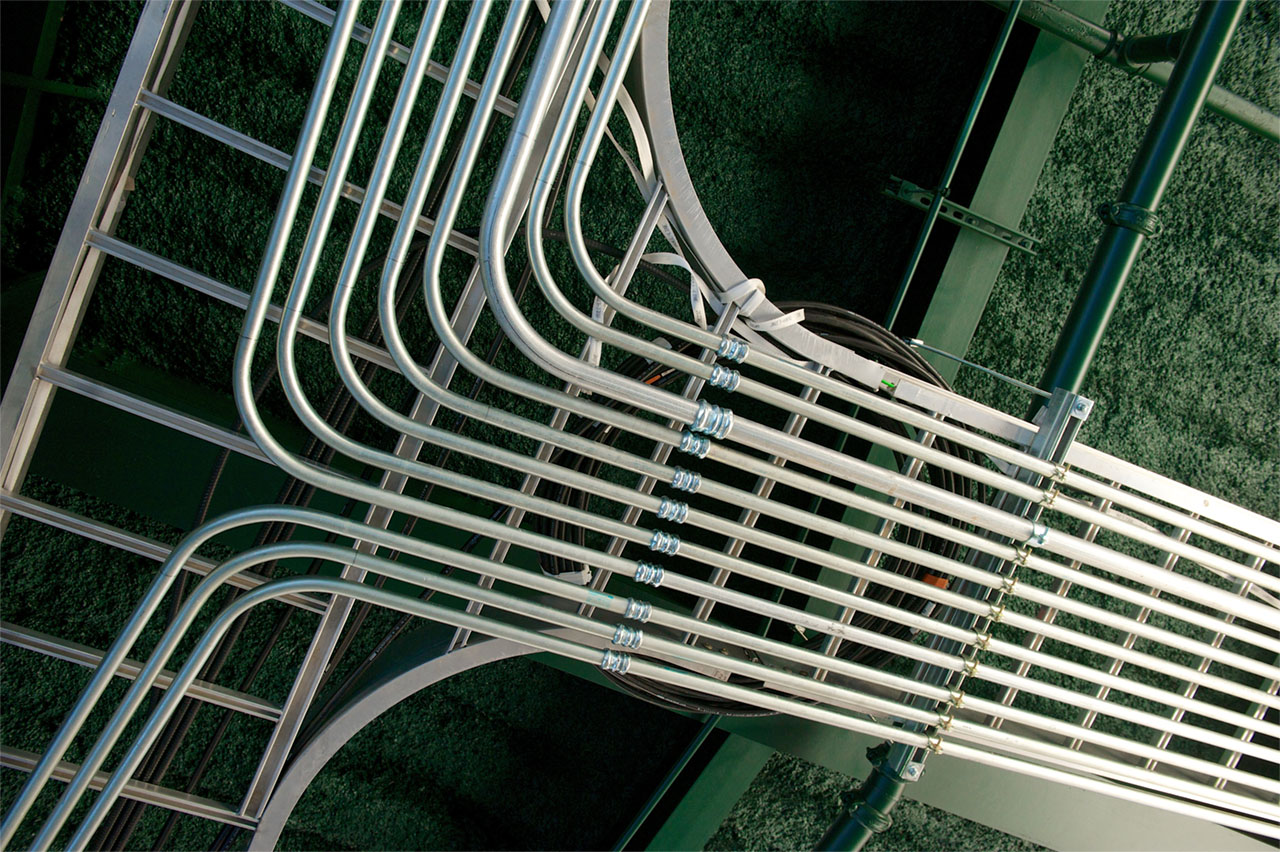 A complex electrical metallic tubing structure installed on the green ceiling
