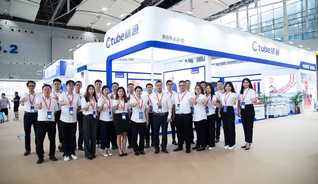 All Ctube collegues in white T-shirts and black pants stood in front of the booth and took a group photo with their thumbs up.
