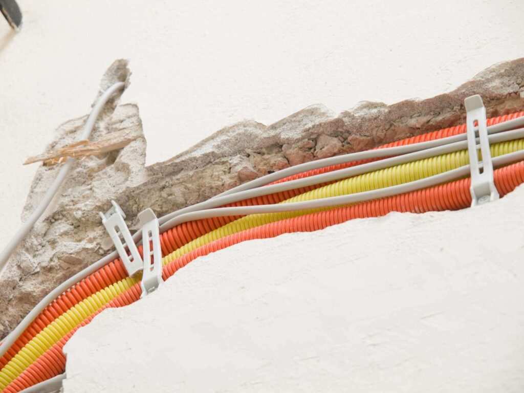 Un tube électrique non métallique flexible (ENT) est acheminé à travers un plafond résidentiel, permettant une rénovation facile dans les espaces restreints.